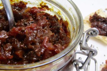 Spicy Tomato Chutney in a glass jar with a spoon