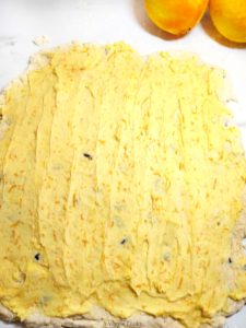 Vegan scone dough with orange butter spread on it