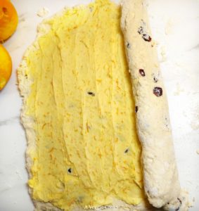 Vegan scone dough with orange butter spread on it