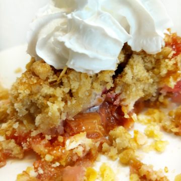 Rhubarb crumble on a plate with vegan cream