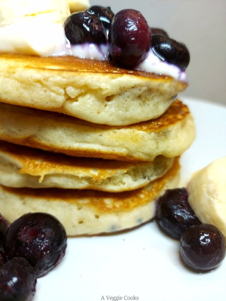Vegan Blueberry Pancakes topped with vegan yogurt and bananas
