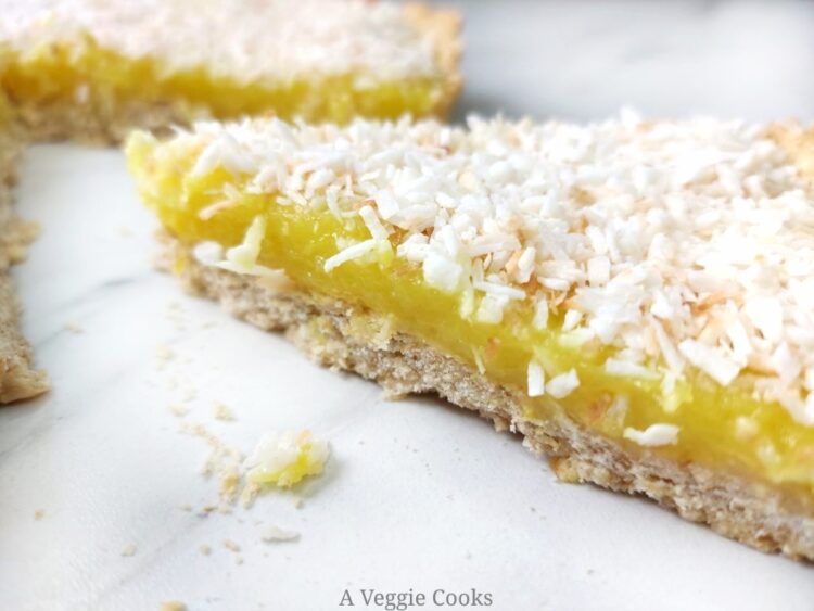 Vegan lemon slice topped with coconut on a white surface