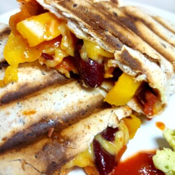 Cooked tortilla wrap with salsa, yellow pepper, kidney beans and vegan cheese
