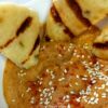 Baba Ganoush in a bowl with sesame seeds and grilled bread wedges