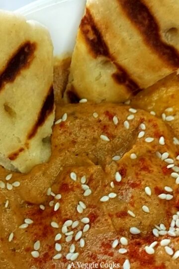 Baba Ganoush in a bowl with sesame seeds and grilled bread wedges