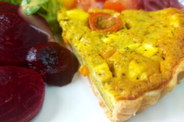 Slice of vegan quiche with sliced beetroot and tomatoes