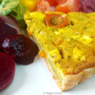 Slice of vegan quiche with sliced beetroot and tomatoes